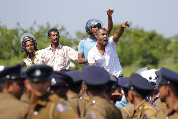 Sri Lankan villagers shout slogans during a protest in Mirijjawila village in Ambalantota, Sri Lanka, on Jan. 7, 2017. Sri Lankan police used water cannons to try to break up violent clashes between government supporters and villagers marching against what they say is a plan to take over private land for an industrial zone in which China will have a major stake. The government has signed a framework agreement for a 99-year lease of the Hambantota port with a company in which China will have 80 percent ownership. Officials also plan to set up the nearby industrial zone where Chinese companies will be invited to set up factories. (AP Photo/Eranga Jayawardena)