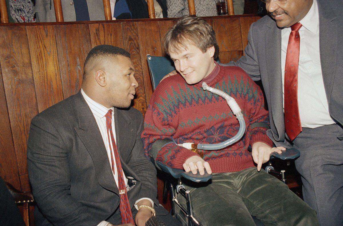 Mike Tyson (R) meets with paralyzed police officer Steven McDonald at the Patrolmen's Benevolent Association Christmas party held at Jimmy Weston's restaurant in New York. (AP Photo/Gerald Herbert)