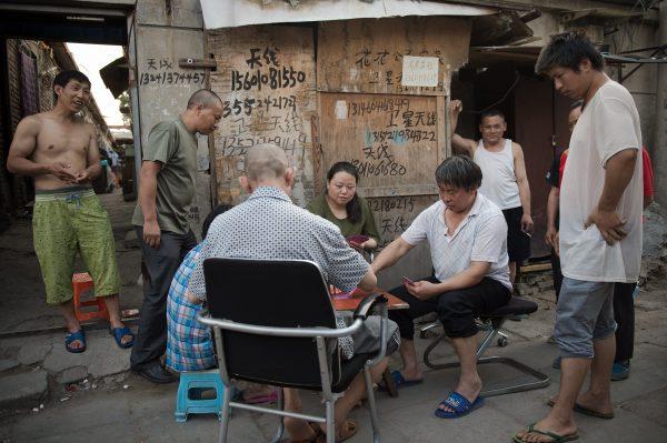 People play cards in a migrant village on the outskirts of Beijing on June 20, 2017. (Nicolas Asfouri/AFP/Getty Images)