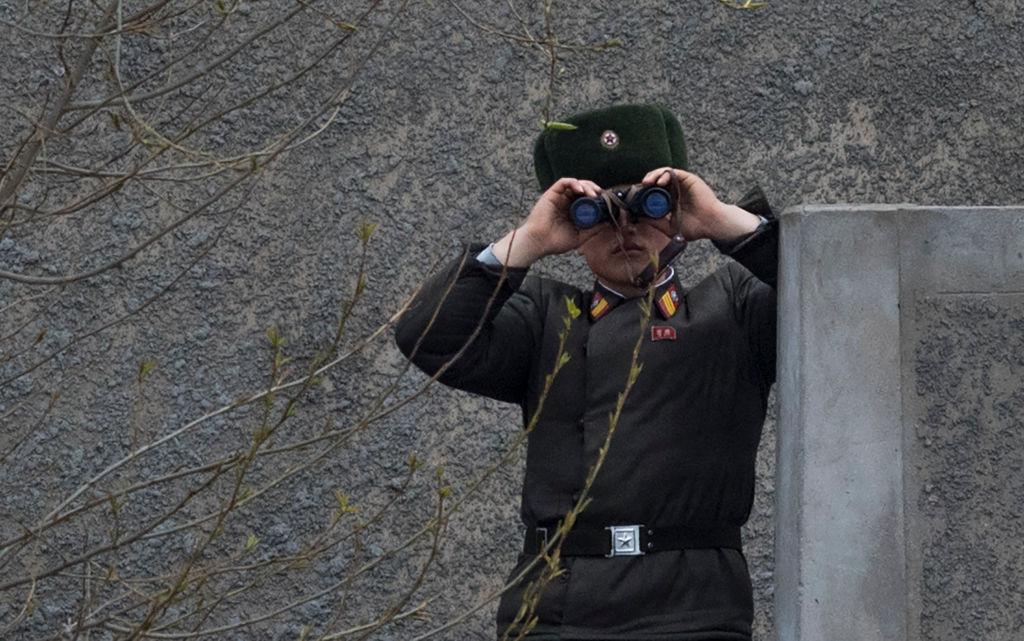 A North Korean soldier uses his binoculars to look across the Yalu river near Sinuiju, opposite the Chinese border city of Dandong on April 14, 2017. (JOHANNES EISELE/AFP/Getty Images)