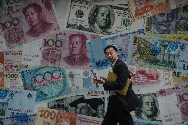 A man walks past a display showing different currencies in Hong Kong on Nov. 9, 2016. (Anthony Wallace/AFP/Getty Images)
