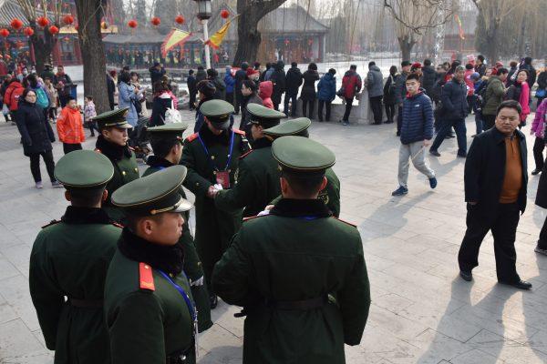 Chinese paramilitary police officers watch over a crowd at a Lunar New Year temple fair in Beijing on February 19, 2018. (Greg Baker/AFP/Getty Images)