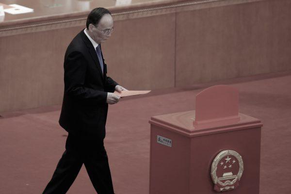 Wang Qishan, former head of the Central Commission for Discipline Inspection, walks with his ballot at a session of China's rubber-stamp parliament, the National People's Congress, at the Great Hall of the People in Beijing, China, on March 17, 2018. (Jason Lee/Reuters)