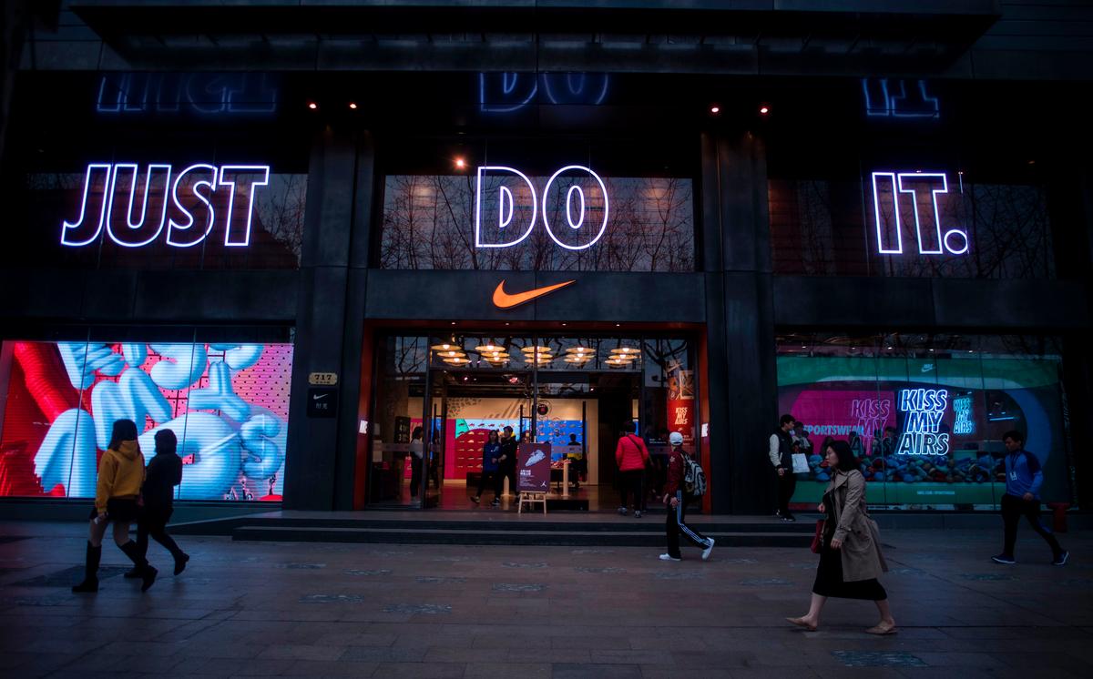 People pass by the flagship store of sporting-goods giant Nike in Shanghai, China, on March 16, 2017. (Johannes Eisele/AFP/Getty Images)