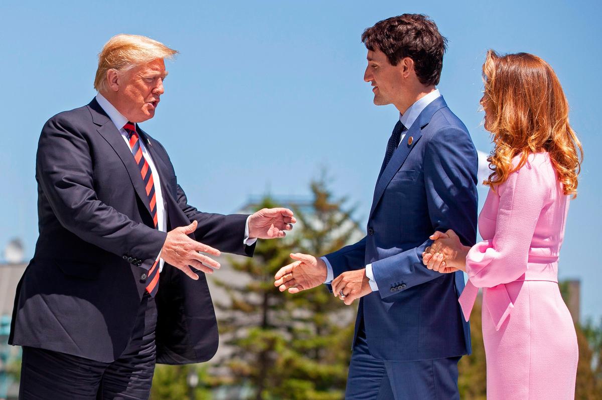 US President Donald Trump (L) is greeted by Canadian Prime Minister Justin Trudeau (C) and his wife, Sophie Gregoire Trudeau, on the first day of the G7 Summit in La Malbaie, Quebec, Canada, June 8, 2018. (GEOFF ROBINS/AFP/Getty Images)