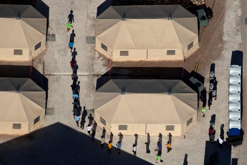 Immigrant children are led by staff in single file between tents at a detention facility next to the Mexican border in Tornillo, Texas, June 18, 2018. Picture taken June 18, 2018. (Mike Blake/Reuters/File Photo)