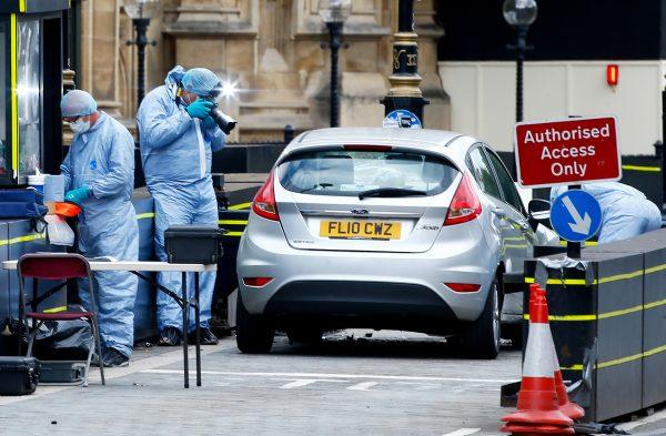 Forensic investigators work at the site after a car crashed outside the Houses of Parliament in Westminster, London on Aug. 14, 2018. (Reuters/Henry Nicholls)