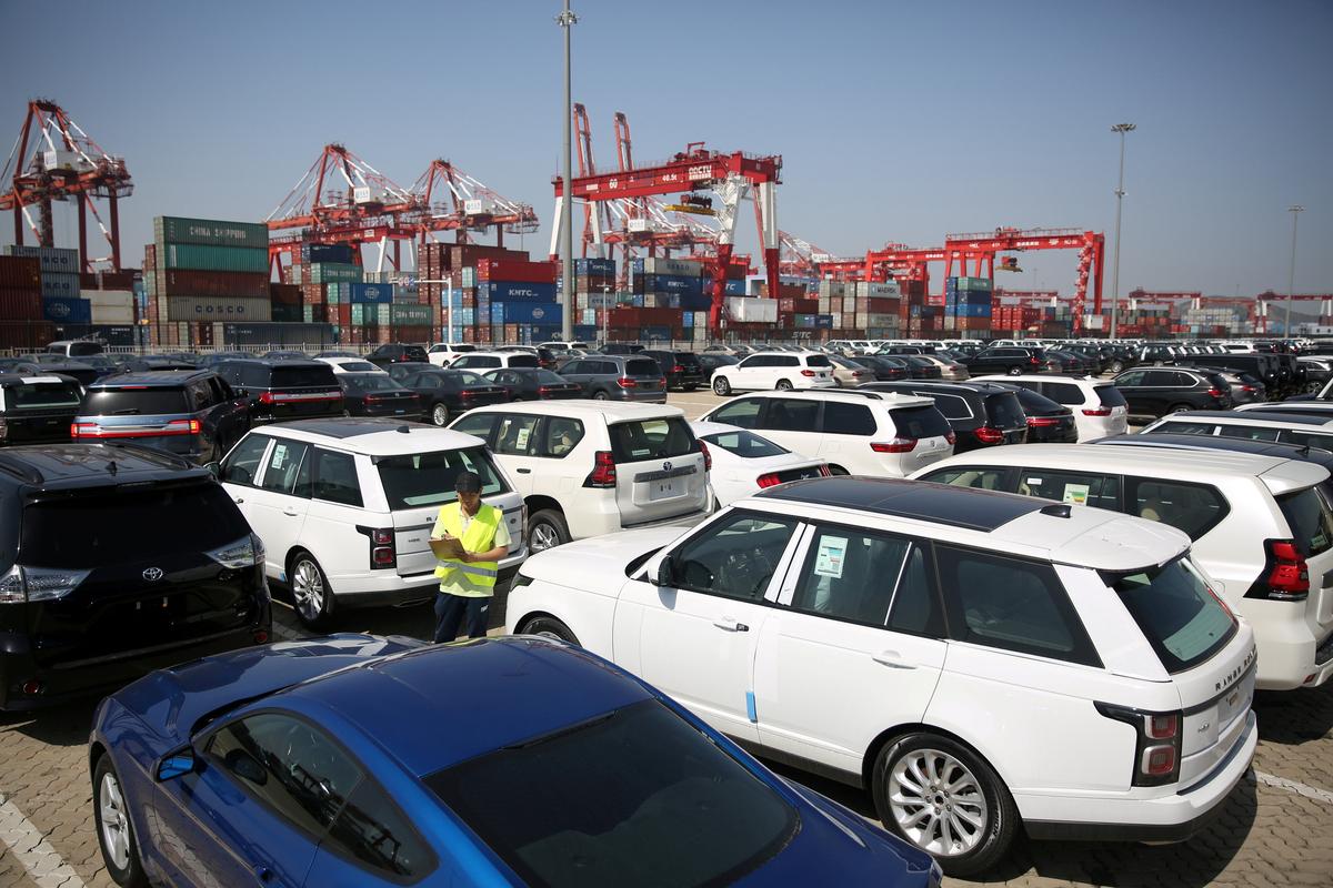 A worker inspects imported cars at a port in Qingdao City, Shandong Province, China, on May 23, 2018. (Stringer/Reuters)