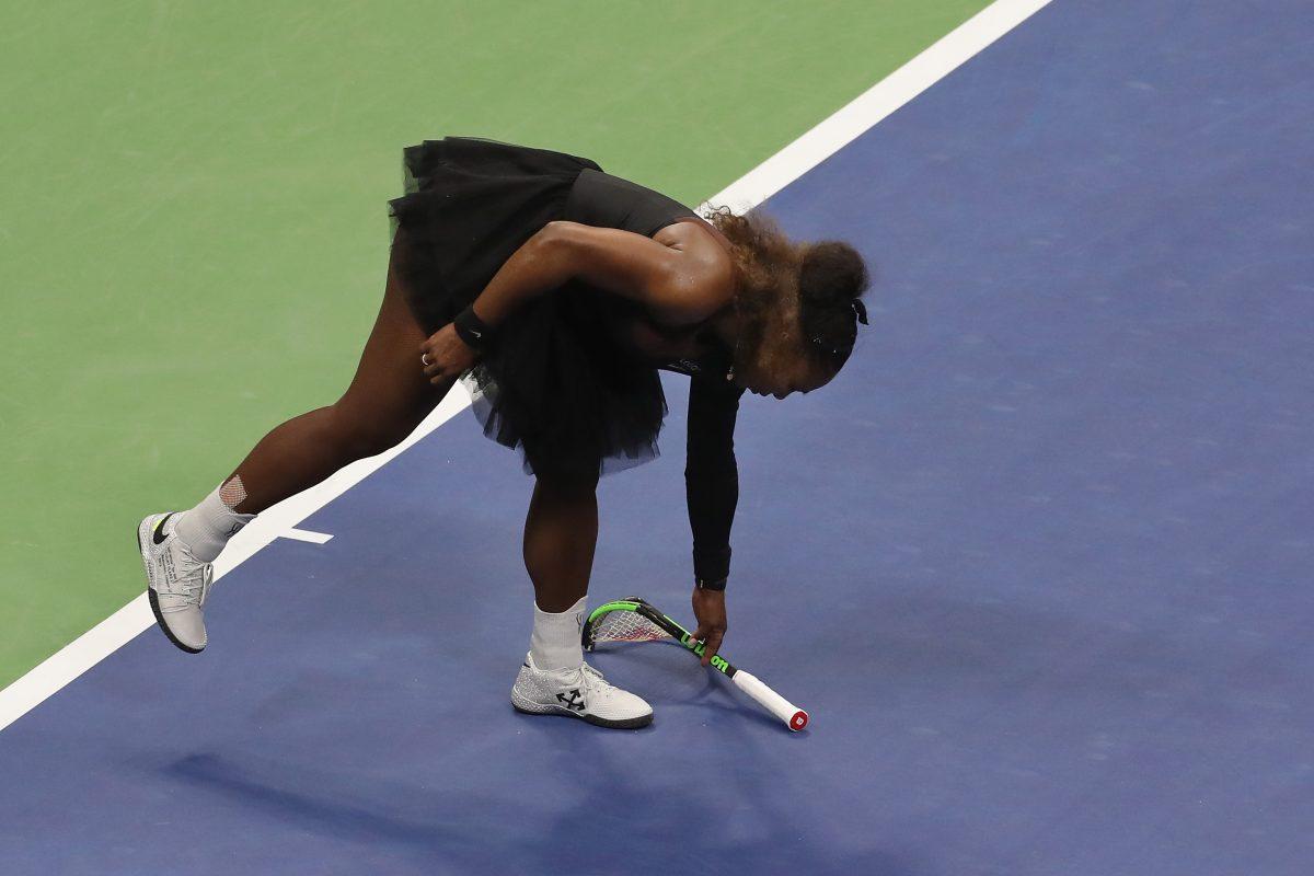 Serena Williams of the United States picks up her smashed racket during her Women's Singles finals match in New York, on Sept. 8. (Jaime Lawson/Getty Images)