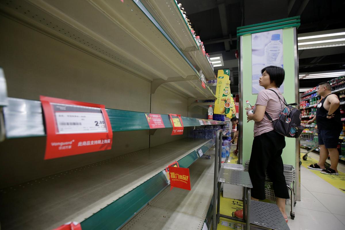 A local resident selects bottled water at a supermarket in preparation for Typhoon Mangkhut, in Shenzhen, China September 15, 2018. (By Jason Lee/Reuters)