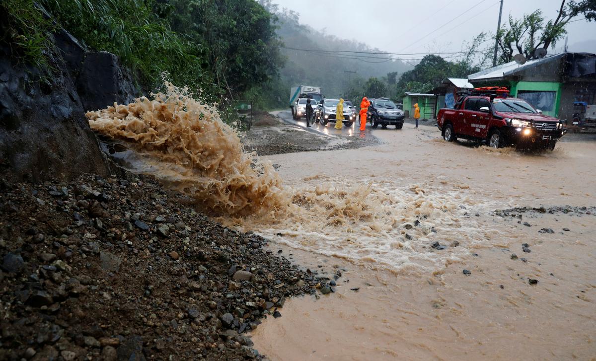 Motorists drive past a partially damaged road after Typhoon Mangkhut hit the main island of Luzon, in Carranglan, Nueva Ecija, Philippines, September 15, 2018. (By Erik De Castro/Reuters)