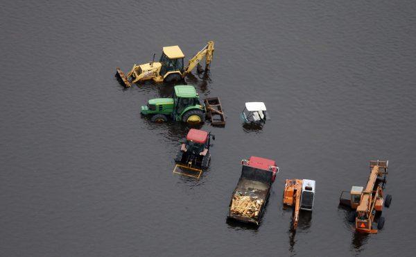 Farm equipment is positioned in a flooded field near Trenton, NC., Sunday, Sept. 16, 2018. (AP Photo/Steve Helber)
