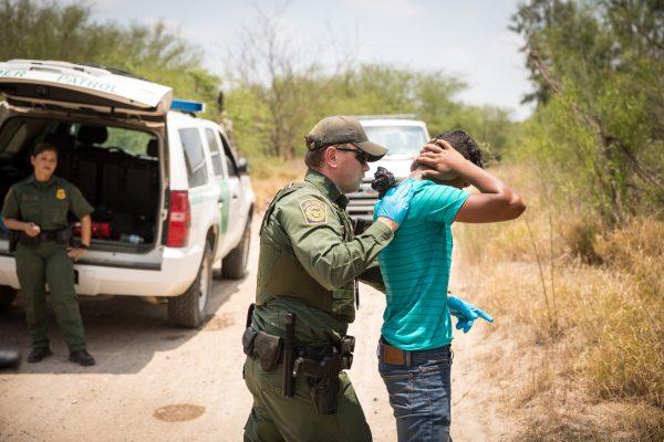 A Border Patrol agent pats down a man who crossed the Rio Grande illegally, in Hidalgo County, Texas, on May 26, 2017. (Benjamin Chasteen/The Epoch Times)