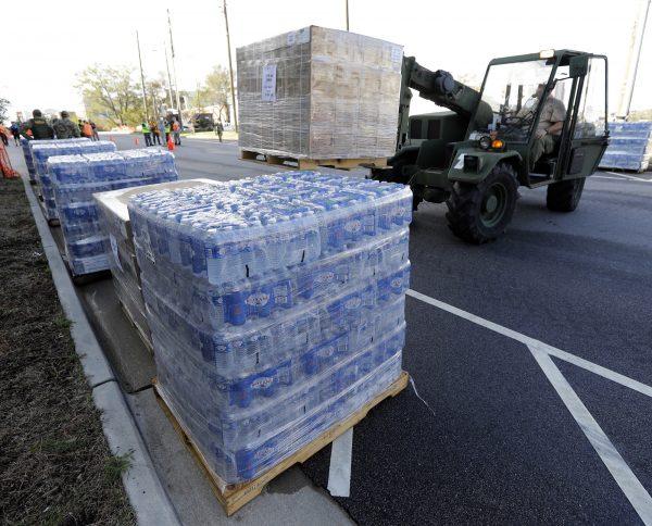 A member of the Civil Air Patrol brings in pallets of MREs and water to hand out at a distribution area in Wilmington, N.C., Sept. 18, 2018. (AP Photo/Chuck Burton)