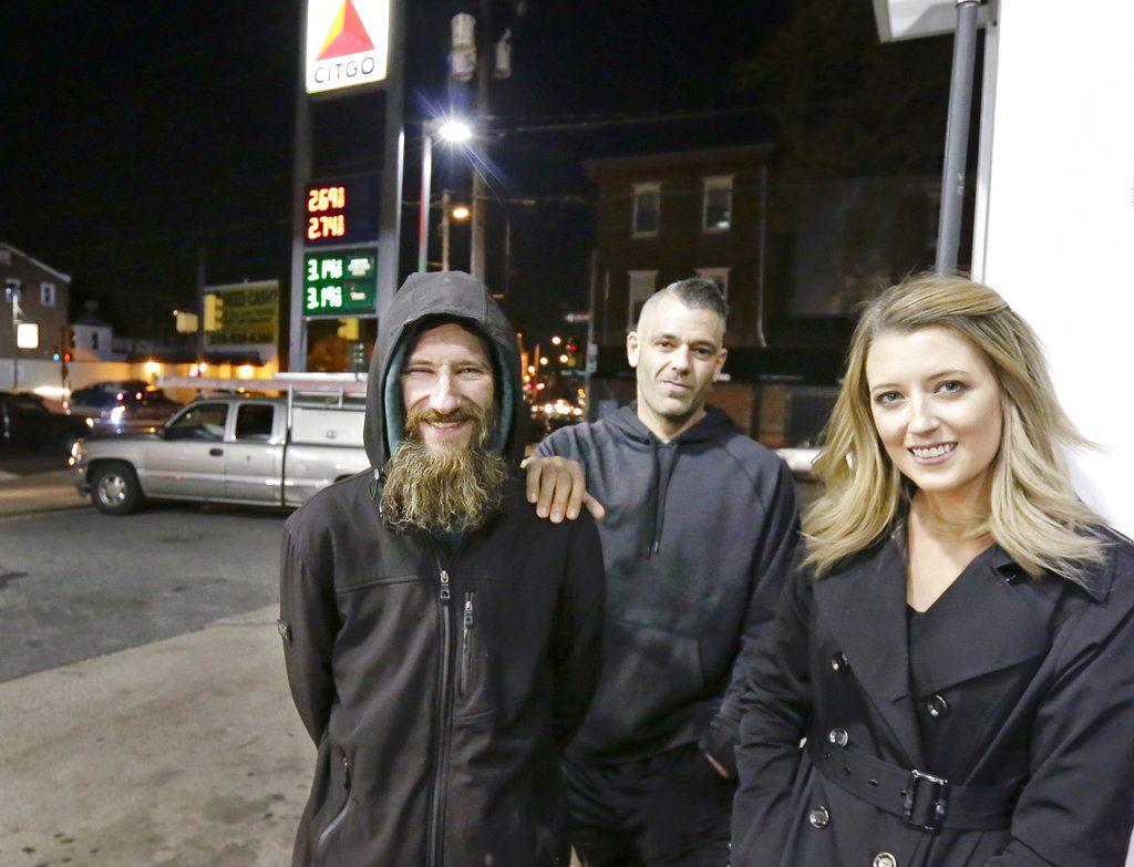 Johnny Bobbitt Jr., left, Kate McClure, right, and McClure's boyfriend, Mark D'Amico, pose at a Citgo station in Philadelphia on Nov. 17, 2017. (Elizabeth Robertson/The Philadelphia Inquirer via AP)