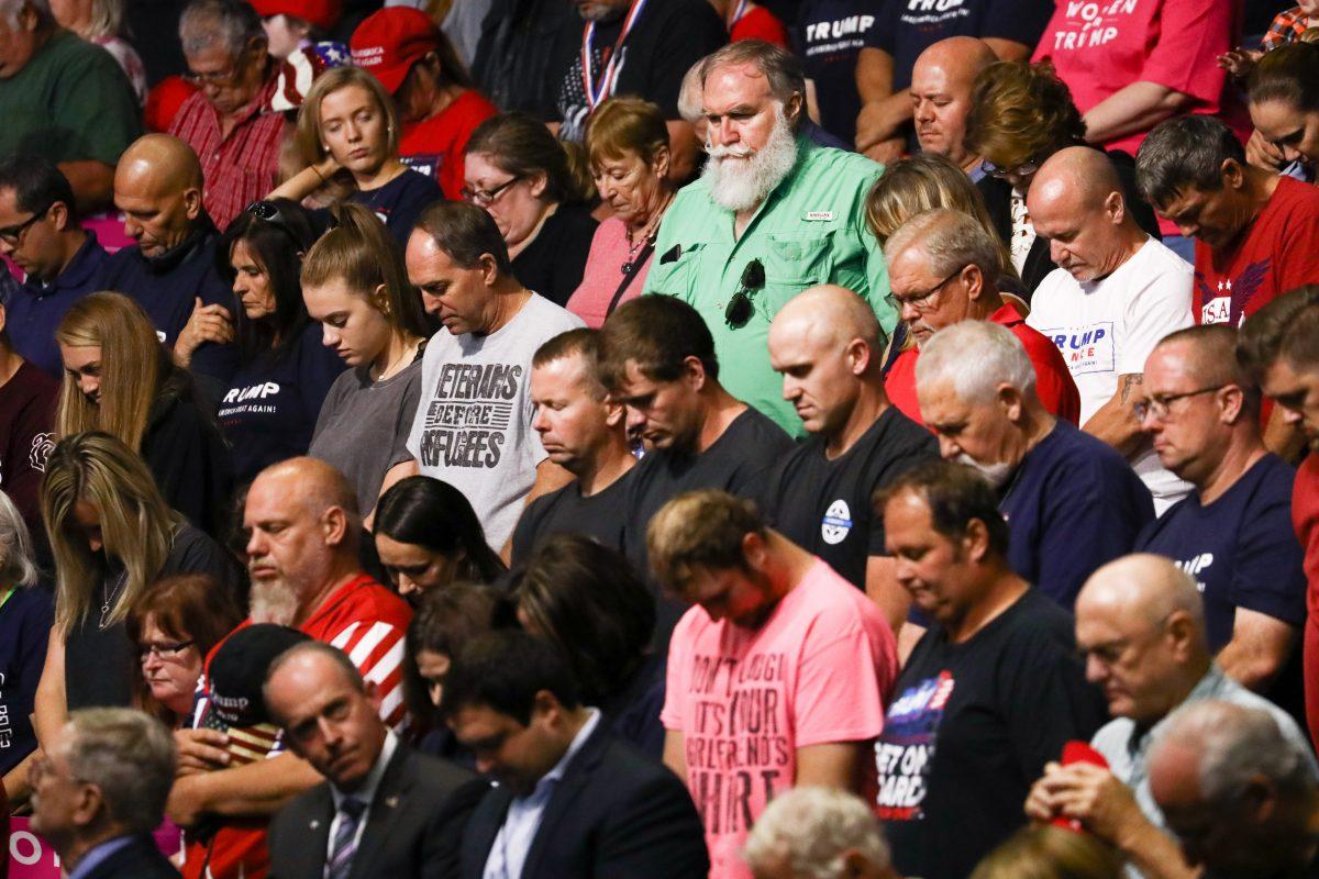 Attendees bow their heads in prayer before President Donald Trump’s Make America Great Again rally in Springfield, Mo., Sept. 21, 2018. (Charlotte Cuthbertson/The Epoch Times)