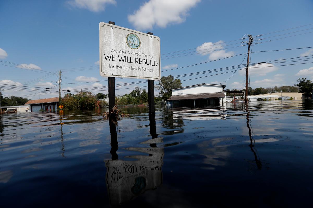 A sign commemorating the rebuilding of the town of Nichols, which was flooded two years earlier from Hurricane Matthew, stands in floodwaters in the aftermath of Hurricane Florence in Nichols, S.C., Sept. 21, 2018. Virtually the entire town is once again flooded and inaccessible except by boat. (AP Photo/Gerald Herbert)
