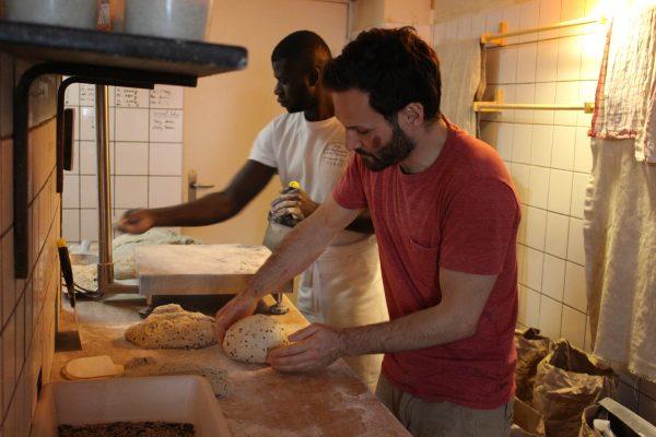 Employee Guilhem Rihet (R) and apprentice Mamadou Dabo shape bread into loaves. (Alexia Luquet/Special to The Epoch Times)