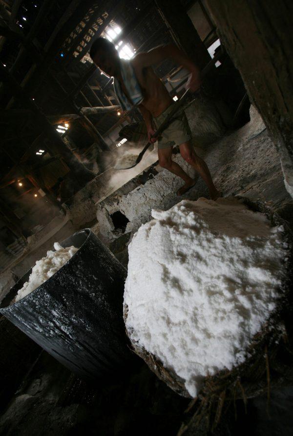 A worker transports table salt from a boiler in the workshop of the Shenhai Salt Well on October 3, 2007 in Zigong of Sichuan Province, China. (China Photos/Getty Images)