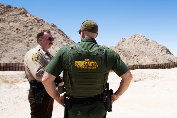 Sheriff Leon Wilmot (L) speaks with a Border Patrol agent by the U.S.–Mexico border near Yuma, Ariz., on May 25, 2018. (Samira Bouaou/The Epoch Times)