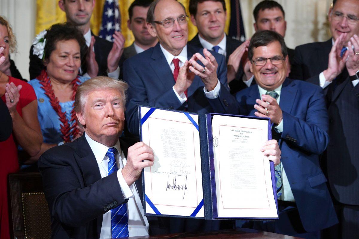 Trump holds up the bill after signing the Department of Veterans Affairs Accountability and Whistleblower Protection Act of 2017 at the White House on June 23, 2017. (MANDEL NGAN/AFP/Getty Images)
