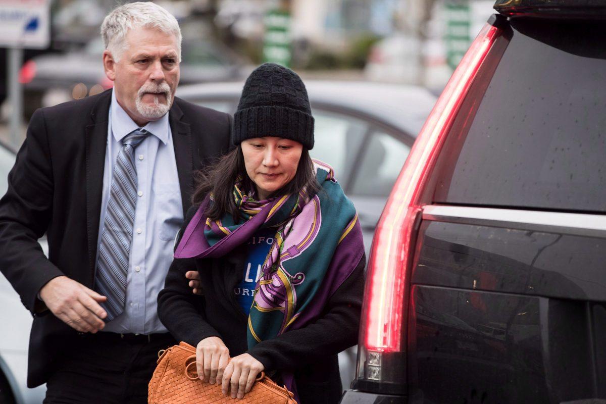 Huawei chief financial officer Meng Wanzhou arrives at a parole office with a member of her private security detail in Vancouver, on Dec. 12, 2018. (The Canadian Press/Darryl Dyck)