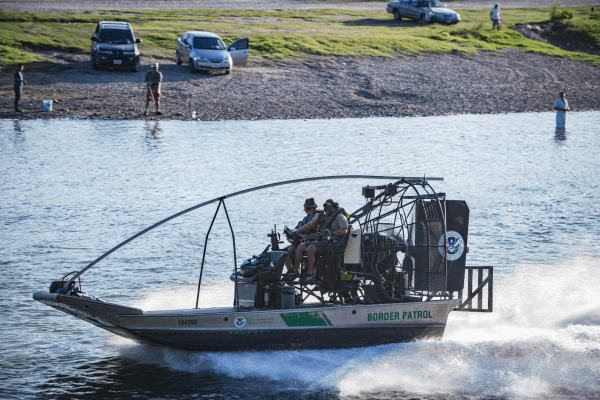 Customs and Border Patrol agents monitor the Rio Grande on a boat between the Mexico city of Ciudad Miguel Aleman (far side) and the Texas city of Roma on May 31, 2017. (Benjamin Chasteen/The Epoch Times)
