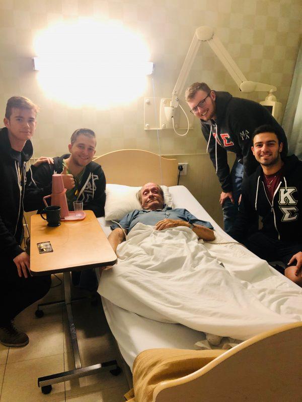 Robert Lewis lays in his hospital bed surrounded by Kappa Sigma fraternity brothers who have pledged to help him avoid homelessness. (Courtesy of Gretchen Smith)