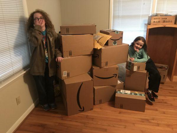 Heath Bertram's daughters, Madison and Anastasia, in their new home next to a pile of goods delivered through a wishlist created by Code of Vets. (Courtesy of Heath Bertram)