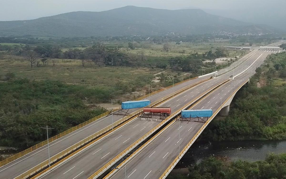 A fuel tanker, cargo trailers, and makeshift fencing blocking the Tienditas International Bridge in an attempt to stop humanitarian aid entering from Colombia, as seen from the outskirts of Cucuta, on Colombia's border with Venezuela on Feb. 6, 2019. (AP Photo)