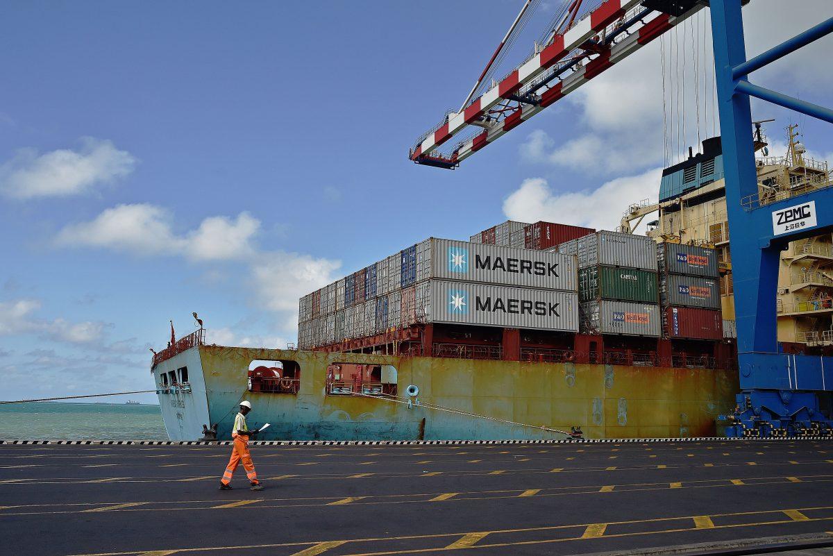 A dock worker passes by a container ship in the Doraleh harbour in Djibouti on May 5, 2015. (CARL DE SOUZA/AFP/Getty Images)