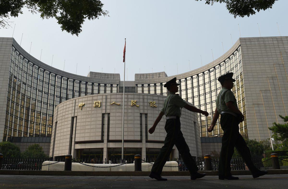 Paramilitary policemen patrol in front of the People's Bank of China, the central bank of China, in Beijing on July 8, 2015. (GREG BAKER/AFP/Getty Images)