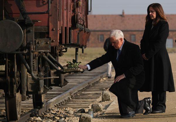 Vice President Mike Pence and second lady Karen Pence lay flowers at a railway car once used to transport inmates at the Auschwitz-Birkenau concentration camp in Oswiecim, Poland, on Feb. 15, 2019. (Sean Gallup/Getty Images)