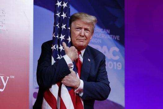 President Trump hugs the American flag as he arrives to speak at the Conservative Political Action Conference in Oxon Hill, Md., on March 2, 2019. (Carolyn Kaster/AP Photo)