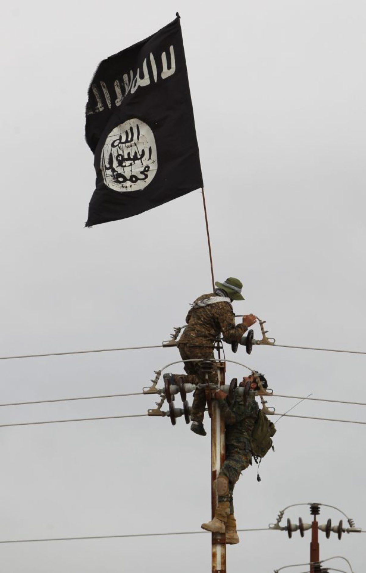 An ISIS flag is taken down from an electricity pole in Samarra, Iraq, on March 3, 2016. (Ahmad Al-Rubaye/AFP/Getty Images)
