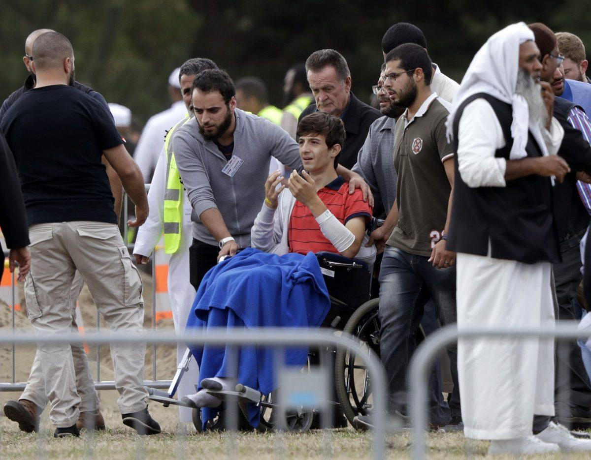 Zaed Mustafa (C) in a wheelchair, brother of Hamza Mustafa and son of Khalid Mustafa, grieves the loss of his brother at the Memorial Park Cemetery in Christchurch, New Zealand, on March 20, 2019. (Mark Baker/AP Photo)