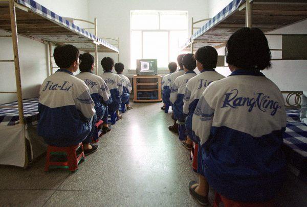 Falun Gong practitioners are shown in Masanjia labor camp watching a video meant to “re-educate” them during a propaganda tour arranged by the camp authorities on May 22, 2001. (AP Photo/John Leicester)