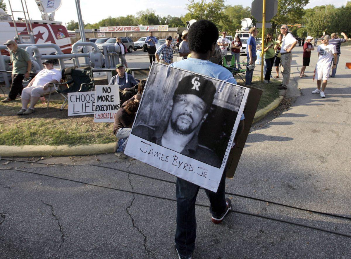 A man wears a photograph of James Byrd Jr. outside the Texas Department of Criminal Justice Huntsville Unit before the execution of Lawrence Russell Brewer in Huntsville, Texas, on Sept. 21, 2011. (David J. Phillip/AP)