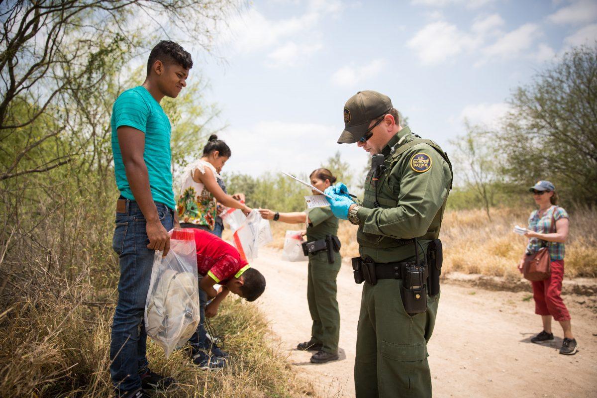 Border Patrol Agents have aliens remove their shoelaces and belongings before loading them in a van for transport in Hidalgo County, Texas, on May 26, 2017. (Benjamin Chasteen/The Epoch Times)