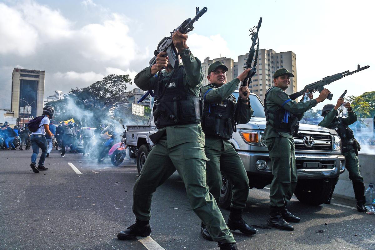 Members of the Bolivarian National Guard who joined Juan Guaido fire into the air to repel forces loyal to Venezuelan regime leader Nicolas Maduro who arrived to disperse a demonstration near La Carlota military base in Caracas on April 30, 2019. (Federico Parra/AFP/Getty Images)