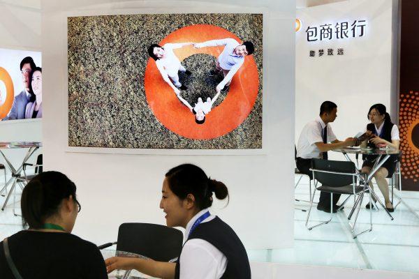 Staff members are seen at the booth of Baoshang Bank at an investment and finance fair for small and medium sized enterprises in Beijing, China on July 18, 2013. (Reuters)