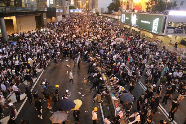 Protesters retreated to the street near the Far East Finance Centre in Hong Kong after police fired off tear gas and pepper spray to disperse the crowd. (Dennis Law/The Epoch Times)