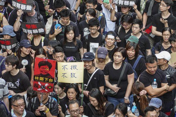 Black-clad protestors took the streets on June 16 to demand the extradition bill’s full retraction and Hong Kong leader Carrie Lam’s resignation. The banners read “Students Are Not Rioters,” “Carrie Lam Step Down” and “No Retreat without Retraction.” (Gang Yu/The Epoch Times)