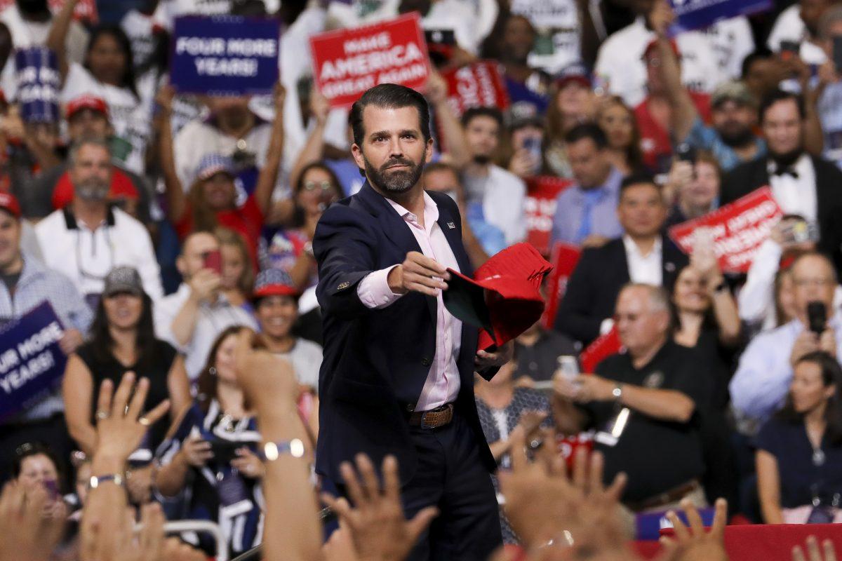 Donald Trump Jr. throws MAGA hats into the crowd at President Donald Trump’s 2020 re-election event in Orlando, Fla., on June 18, 2019. (Charlotte Cuthbertson/The Epoch Times)