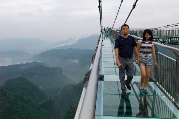 A couple walks on a glass-bottomed skywalk, certified as the world's longest, at the Ordovician park in Wansheng. (Fred Dufour/AFP/Getty Images)