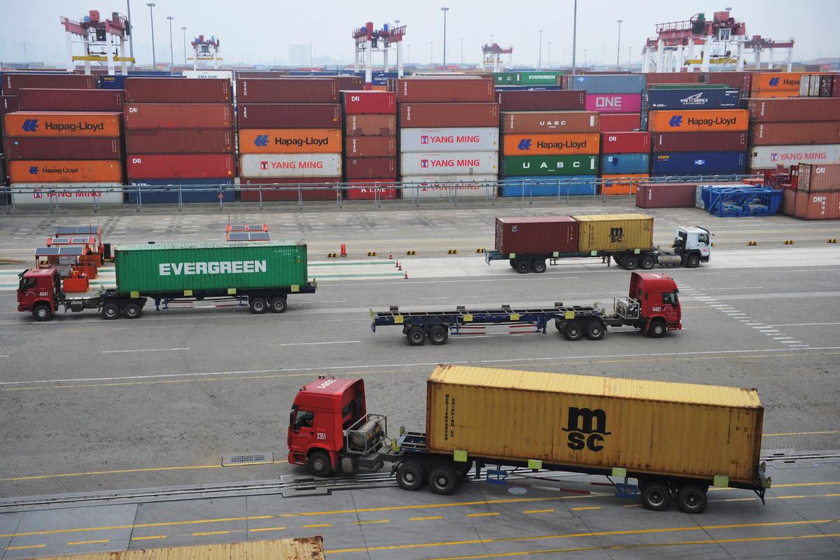 Trucks transport containers at a port in Qingdao, Shandong Province, China on July 11, 2019. (China Out via Reuters)