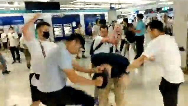 Men in white t-shirts and face masks attack anti-extradition bill demonstrators and reporters at a train station in Hong Kong on July 21, 2019, in this still image obtained from a social media live video. (Courtesy of Stand News/Social Media via Reuters)