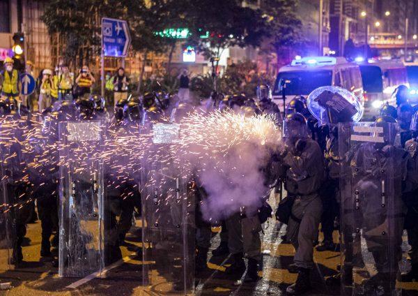 Policemen fire tear gas at retreating protesters after a march against a controversial extradition bill in Hong Kong on July 21, 2019. (Yu Kong/The Epoch Times)