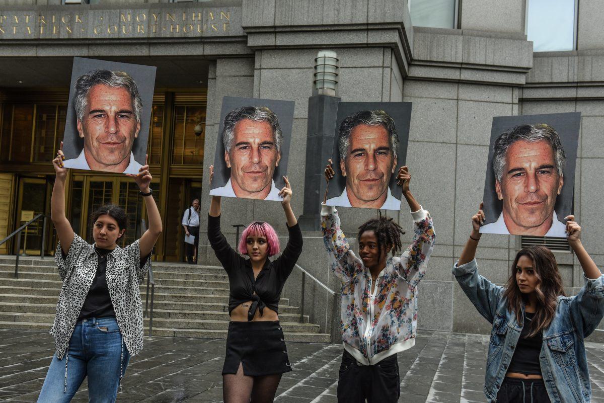 A protest group called “Hot Mess” hold up signs of Jeffrey Epstein in front of the federal courthouse in New York City on July 8, 2019. (Stephanie Keith/Getty Images)