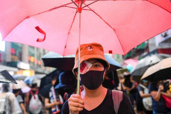 A protester wearing an eye patch, after a woman suffered an eye injury which demonstrators blamed on a bean-bag round fired by police, walks along a street during a rally in Hong Kong on Aug. 18, 2019. (Manan Vatsyayana/AFP/Getty Images)
